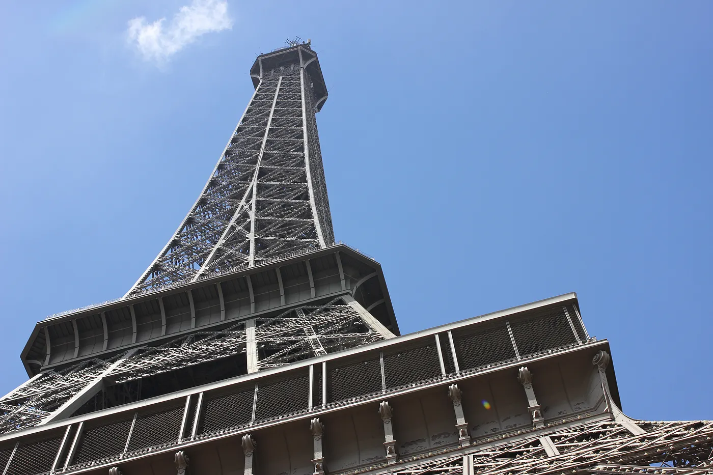 Auto-generated description: A low-angle view of the Eiffel Tower against a clear blue sky.