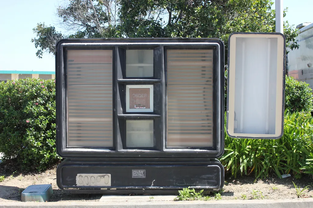 Auto-generated description: A bus stop shelter is designed to resemble a giant television set, complete with a screen and frame.